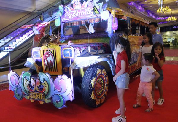  Children walk past a colorfully hand-painted jeepney designed by students of the Mapua Institute of Technology, during the 6th Pinoy Ultimate Jeepney design competition at Resorts World Manila in Pasay City. PHOTO BY BOB DUNGO JR.