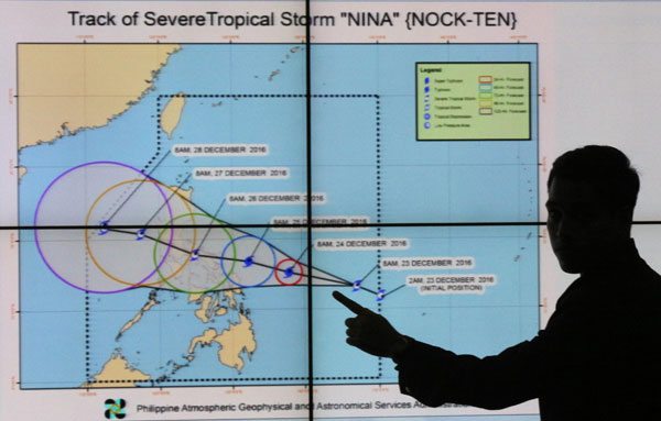 HELLO, NINA Weather forecaster Benison Estareja shows the forecast track of severe tropical storm “Nina,” which is expected to make land fall in Quezon on Monday morning. PHOTO BY RUY L. MARTINEZ