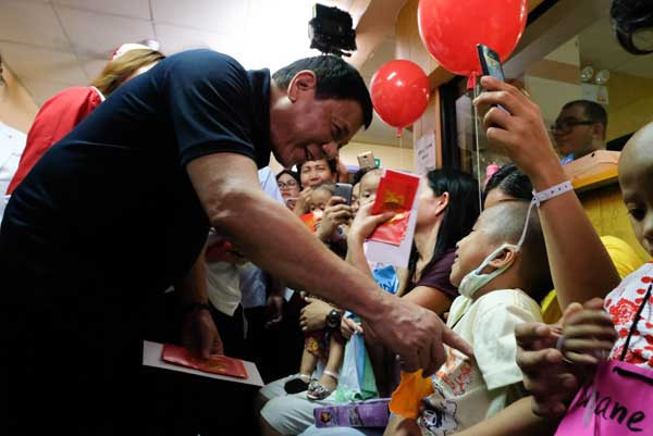 PLAYING SANTA President Rodrigo Duterte visits young cancer patients at the Southern Philippines Medical Center’s House of Hope in Davao City on Saturday. Duterte gave 300 gift packs that contained biscuits, candies, juices, toys and canned goods to the cancer-afflicted children and their caretakers.
