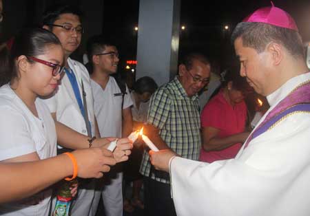 DARKNESS Bishop Joel “Bong” Baylon of the Diocese of Legazpi leads the candle lighting ceremony against extrajudicial killings in the country. PHOTO BY RHAYDZ B. BARCIA
