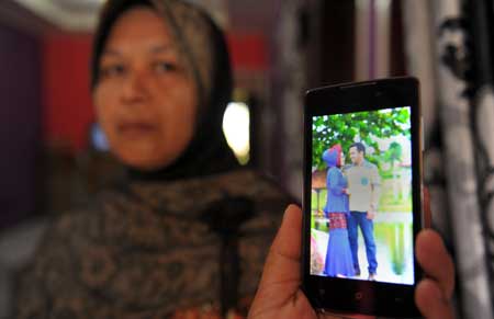 FROM WEDDING TO FUNERAL In this photograph taken on thursday, the mother of yusra Fitriani shows a pre-wedding portrait photo of her daughter and groom in Pidie Jaya, in aceh province, Indonesia. AFP PHOTO