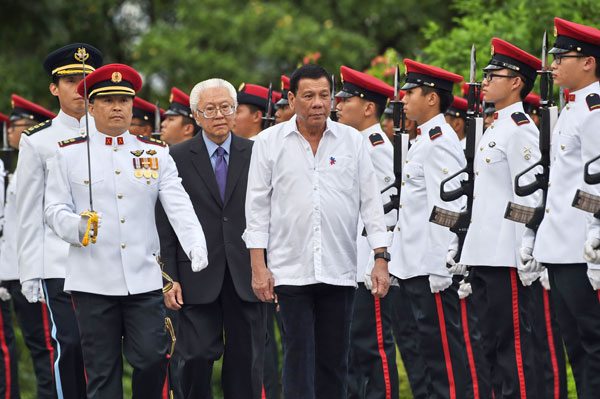 DIGONG IN THE LION CITY President Rodrigo Duterte (center) and Singaporean President Tony Tan (third from left) inspect the guard of honor during a welcome ceremony at Istana presidential palace in Singapore on Thursday. Duterte is on a two-day state visit in Singapore.  AFP PHOTO BY ROSLAN RAHMAN 