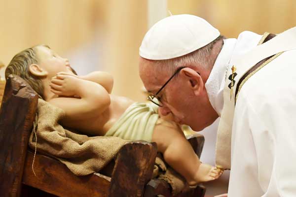 KING OF KINGS Pope Francis kisses a figurine of baby Jesus as he celebrates Mass on Christmas Eve marking the birth of Jesus Christ at St. Peter’s Basilica in the Vatican. AFP PHOTO