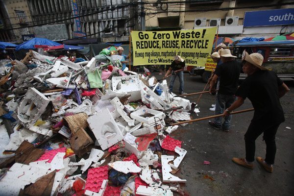 Environmentalists belonging to the Ecowaste Coalition make a statement against unrestrained garbage generation and disposal as the group’s eco-volunteers assist Manila’s waste and sanitation personnel in removing post-holiday trash along Recto Avenue and nearby streets in Divisoria in Manila on Sunday. PHOTO BY RUSSELL PALMA