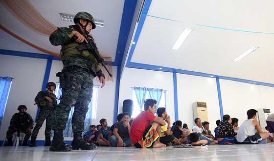 SECURITY CHECK Policemen guard more than 100 men rounded up in Quiapo, Manila on Saturday for profiling. Police authorities raided several areas in Quiapo two days before the procession of the Black Nazarene. PHOTO BY RUSSELL PALMA