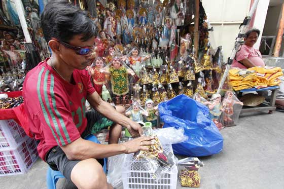 HOT ITEMS A vendor displays small images of the Black Nazarene in his stall near the Quiapo Church on Wednesday as preparations for the Traslacion, one of the country’s biggest religious festivals, reach fever pitch. PHOTO BY BOY JOSUE