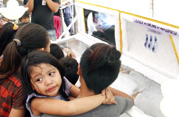 GONE Emilyn’s mother comforts her crying child during the wake held for the teenager felled by a bullet on New Year’s Eve. PHOTO BY MIKE DE JUAN