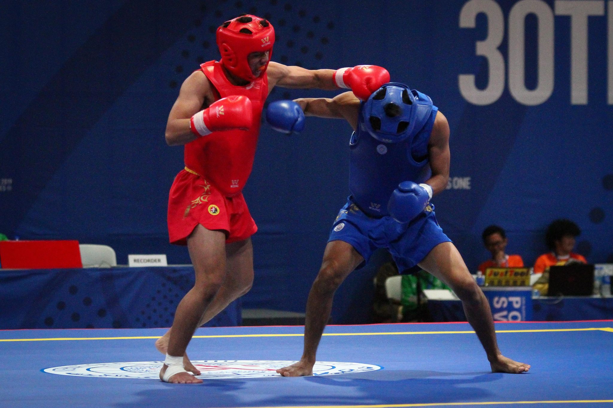 Gideon Fred Padua of the Philippines (red) wins his quarterfinals fight against Jian Hwa Chong (blue) of Indonesia in Wushu Sanda at the World Trade Center, Sunday afternoon. PHOTO BY J. GERARD SEGUIA