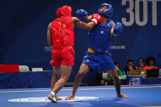 Gideon Fred Padua of the Philippines (red) wins his quarterfinals fight against Jian Hwa Chong (blue) of Indonesia in Wushu Sanda at the World Trade Center, Sunday afternoon. PHOTO BY J. GERARD SEGUIA