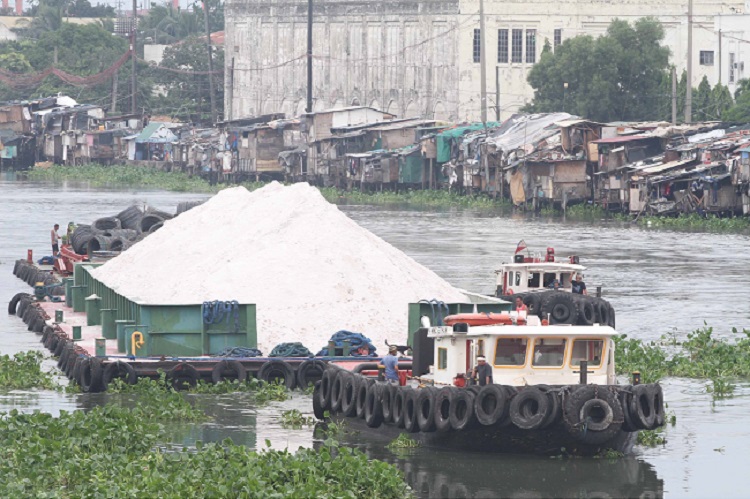 A barge loaded with white sand and metal makes it way through Pasig river in Manila. There had been much debate lately over the dumping of white sand on a stretch in Manila Bay as part of the government’s efforts to rehabilitate it.Photo by Rene H. Dilan